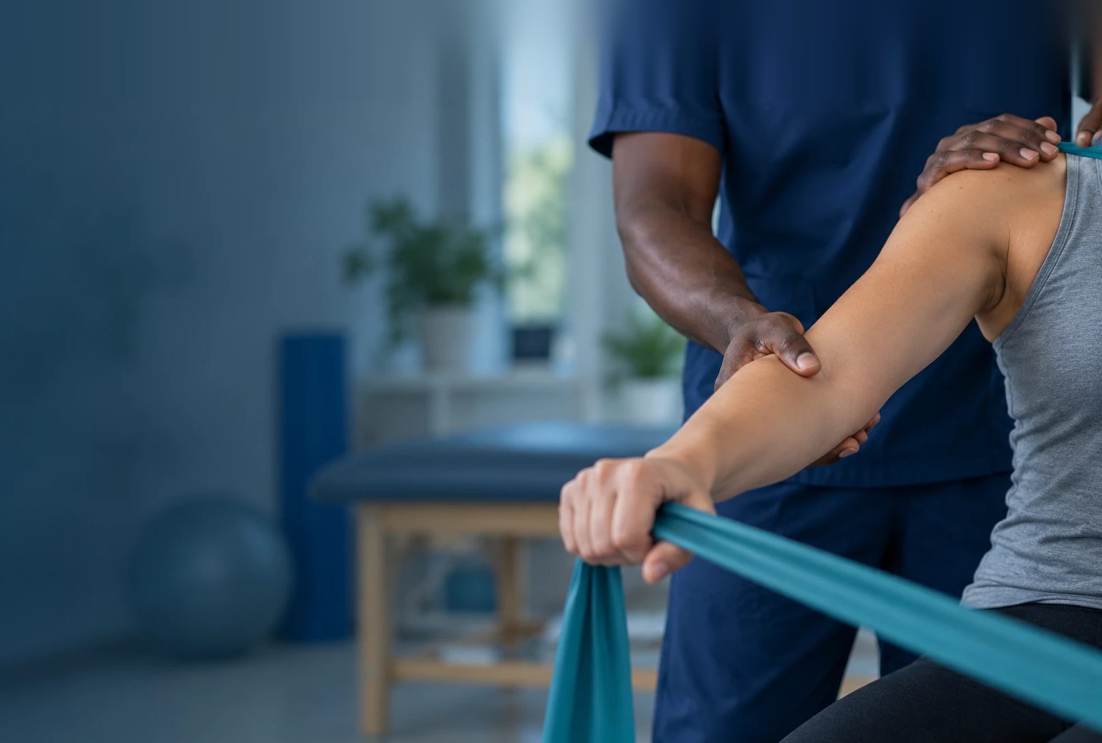 Fisioterapeuta orientando exercício de braço com faixa elástica
